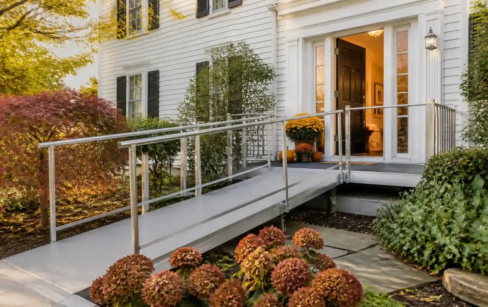 Modular aluminum ramp and level landing at a white Colonial home entrance