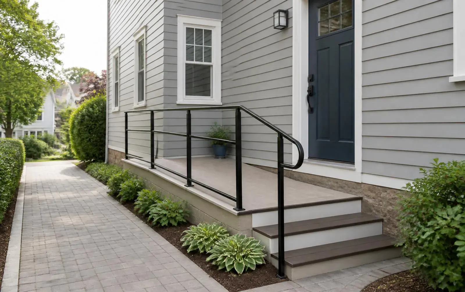 Accessible side entrance with handrails at a Nonantum wood-frame home