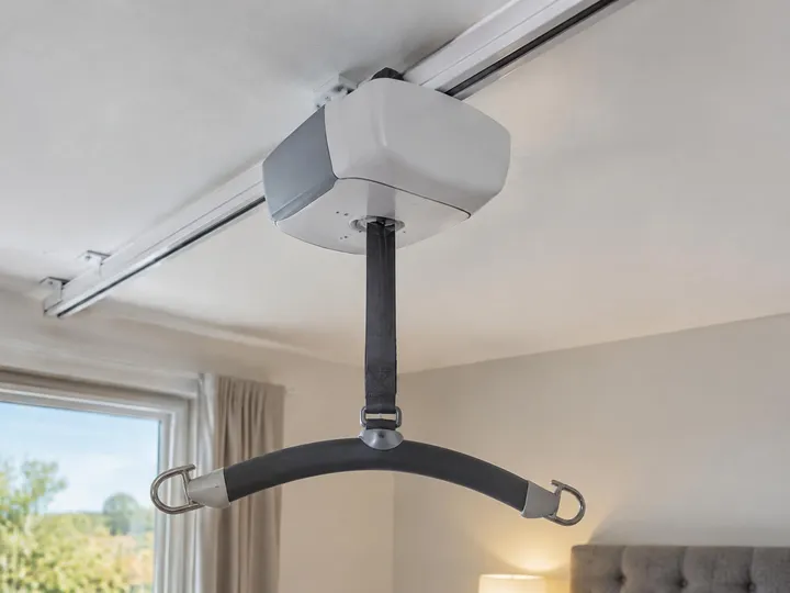 Ceiling track lift motor unit with its lifting strap and spreader bar
